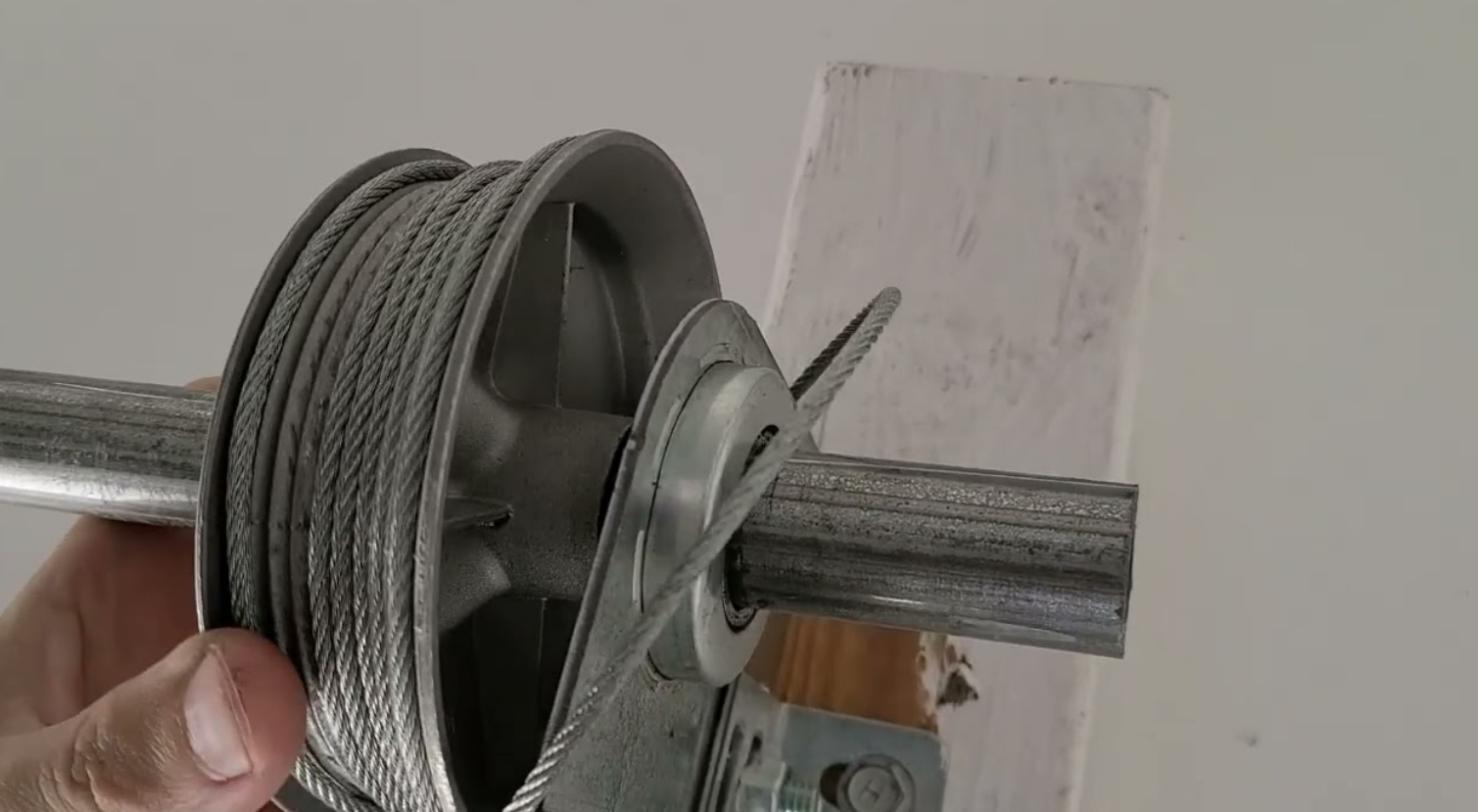 Close-up of a professional technician repairing a garage door cable in Nokomis, FL, showcasing precision and tools used during the garage door cable repair process.