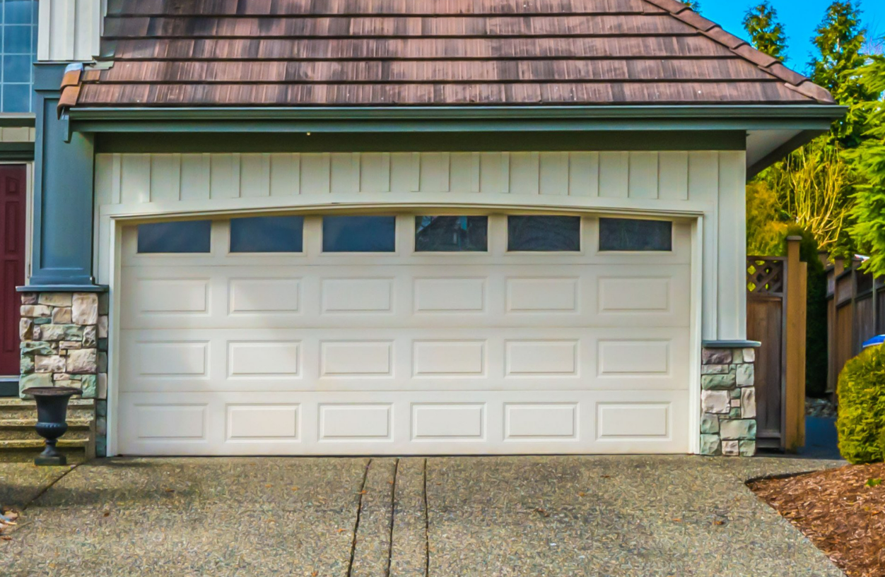 Professional technician repairing a garage door with the company logo in the background, highlighting local garage door repair services in Nokomis, FL.
