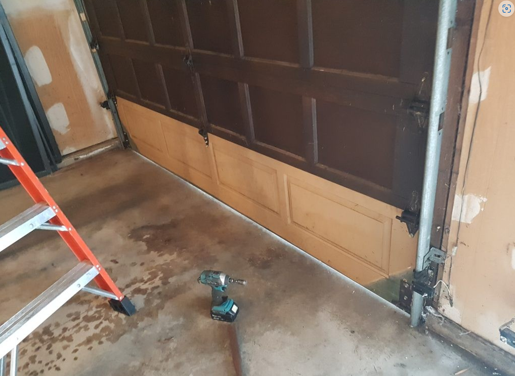 Technician performing garage door panel repair in Nokomis, FL, showcasing professional tools and expertise